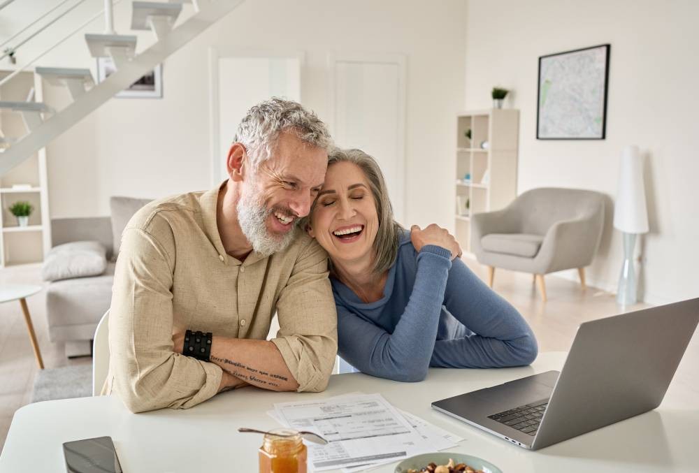 A happy senior couple applying for window treatment financing online near Norfolk, Nebraska (NE)
